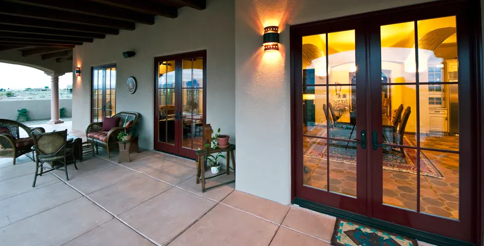 Covered patio with chairs and double doors with beamed ceiling