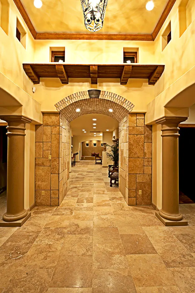Stone-floored entry hall with columns, arch and beams