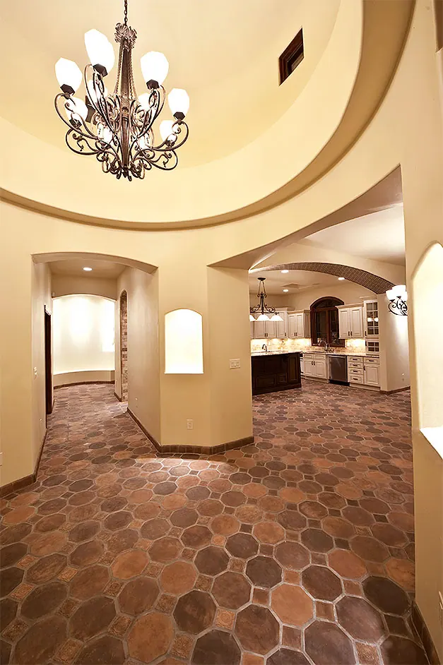 Round vaulted hallway with chandelier and tile floor
